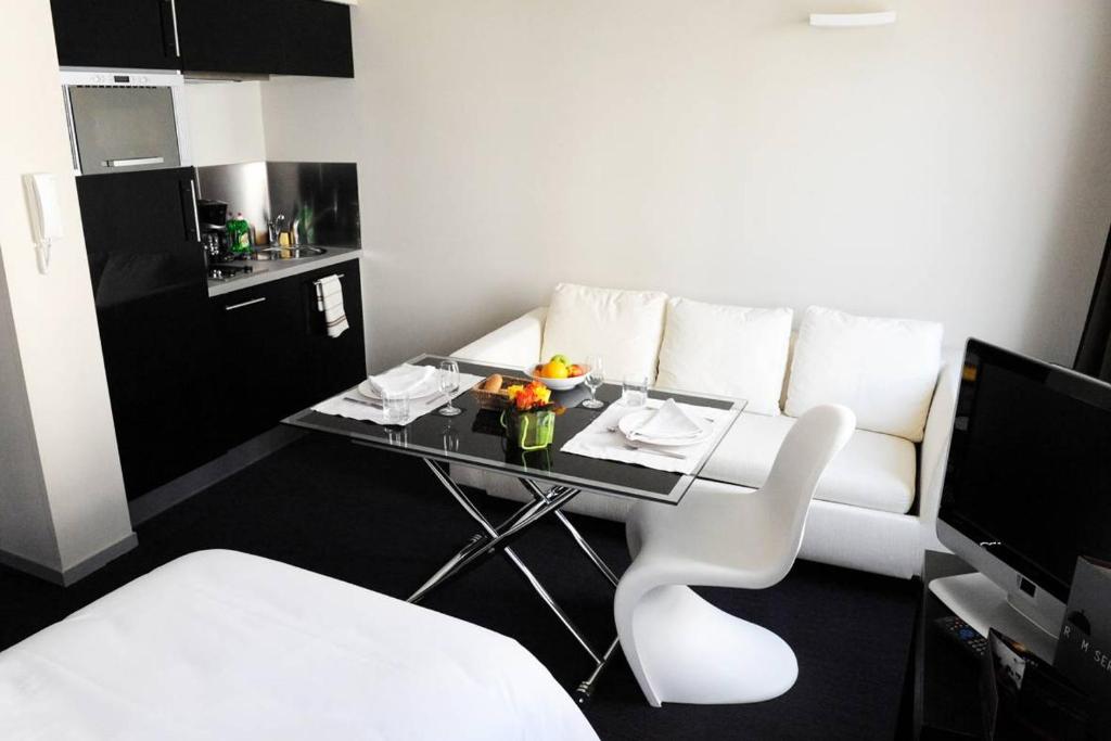 a living room with a table and a white couch at Rex Résidence in Tarbes