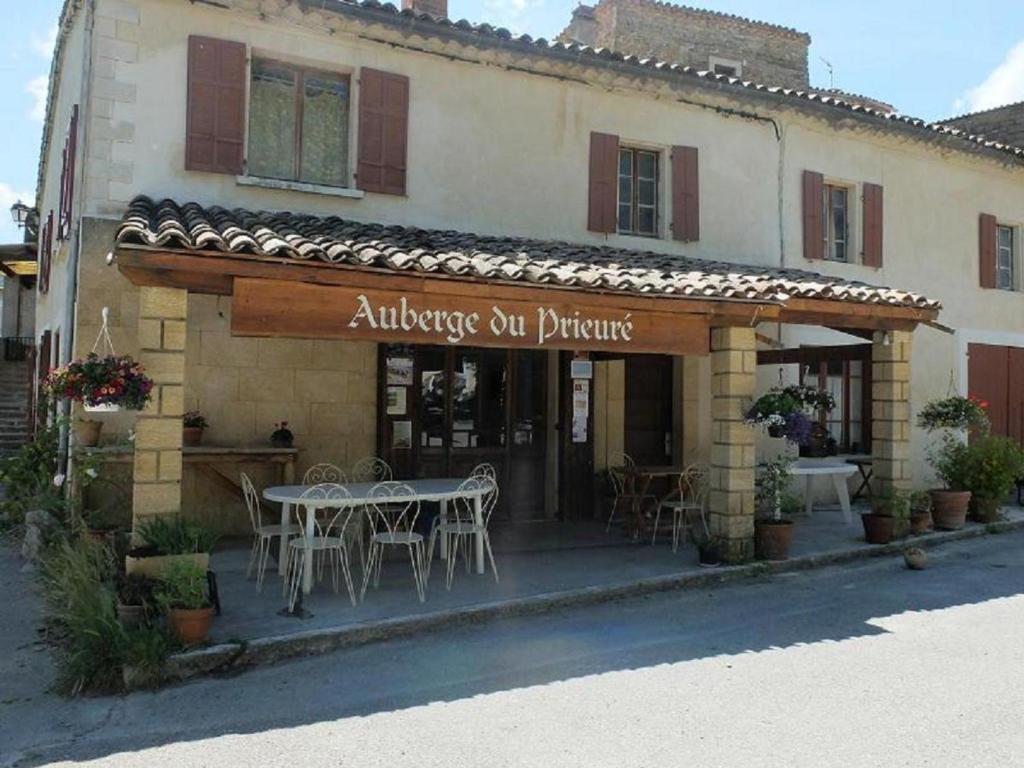 um restaurante com uma mesa em frente a um edifício em Auberge du prieure em Saint-André-de-Rosans