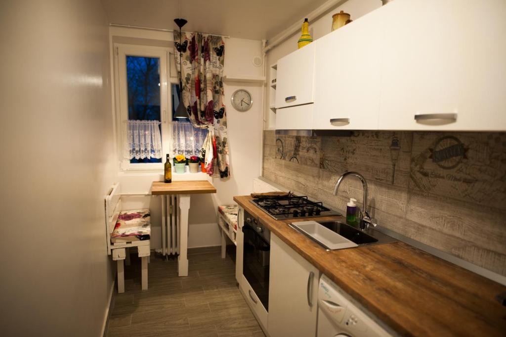 eine Küche mit weißen Schränken und einer Arbeitsplatte in der Unterkunft Nicola's Home in Bukarest