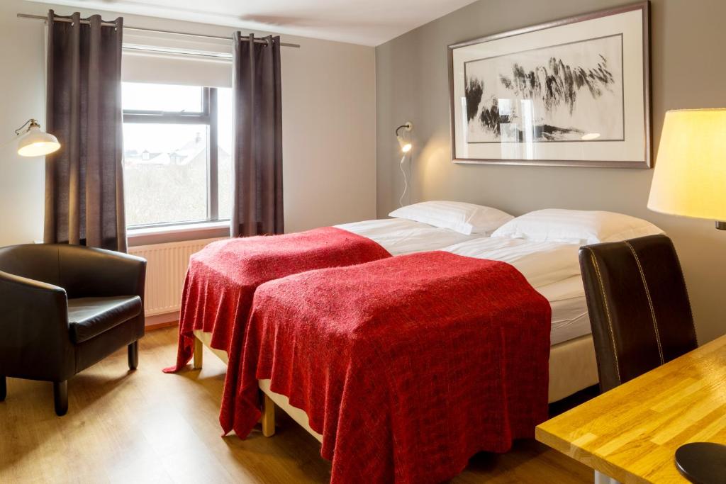 Habitación de hotel con 2 camas y mantas rojas en Guesthouse Sunna, en Reikiavik