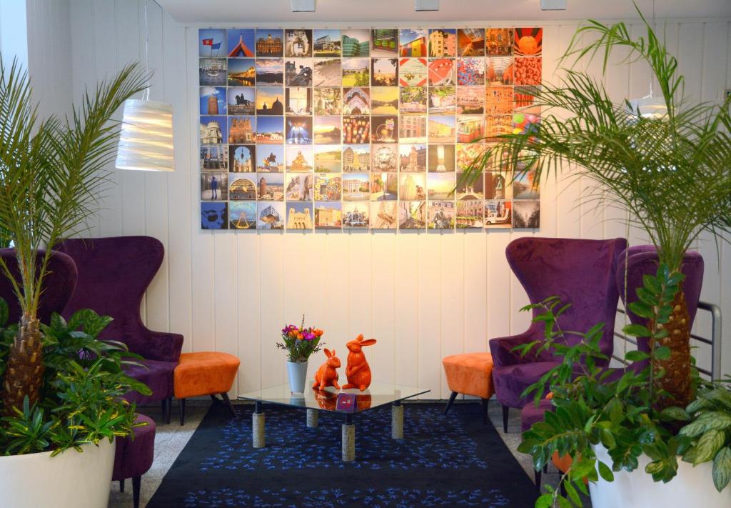 a room with two cats on a table and two chairs at Hotel Gratte-Ciel Ariana in Villeurbanne