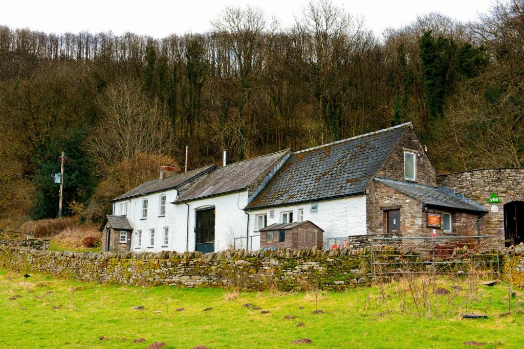 un groupe de maisons blanches dans un champ dans l'établissement YHA Brecon Beacons Danywenallt, à Llansantffread