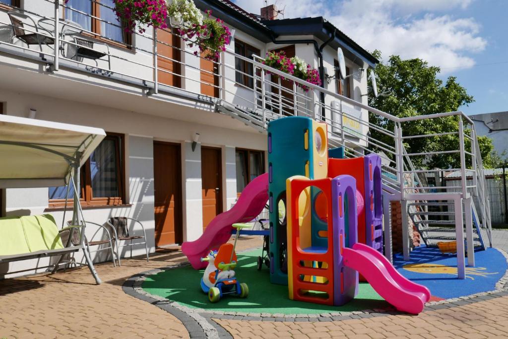un parque infantil frente a una casa en Pokoje Meduza Łeba, en Łeba
