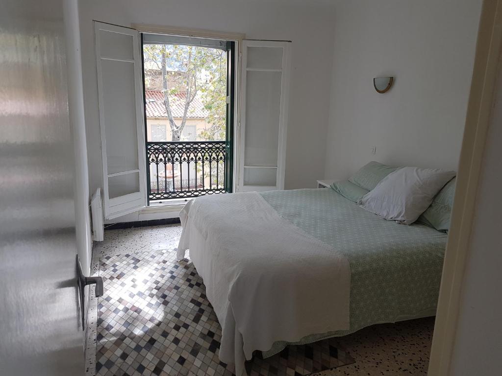 - une chambre avec un lit et une grande fenêtre dans l'établissement Maison Marijke, à Céret