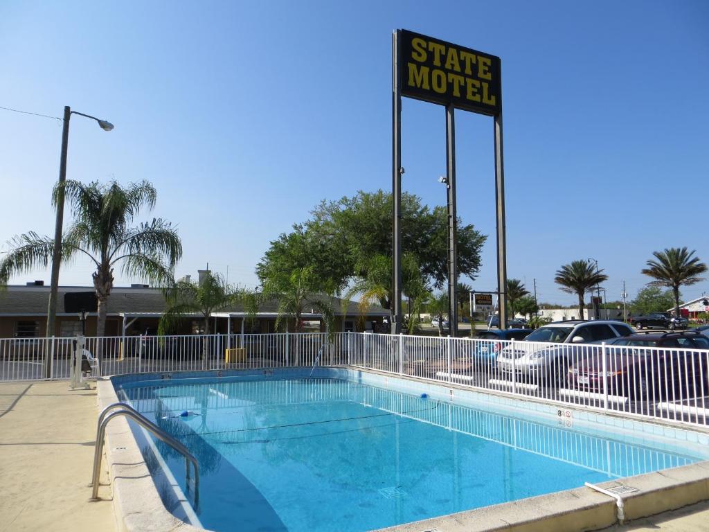 een zwembad met een bord dat staat voor een motel bij State Motel Haines City in Haines City