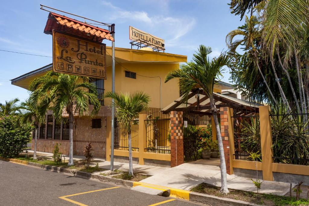 a yellow building with a sign in front of it at Hotel La Punta in Puntarenas