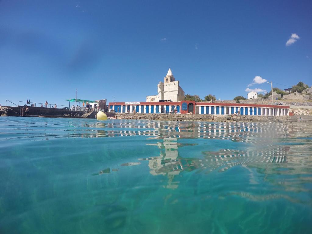 a body of water with a building in the background at Holiday home Marija in Karlobag