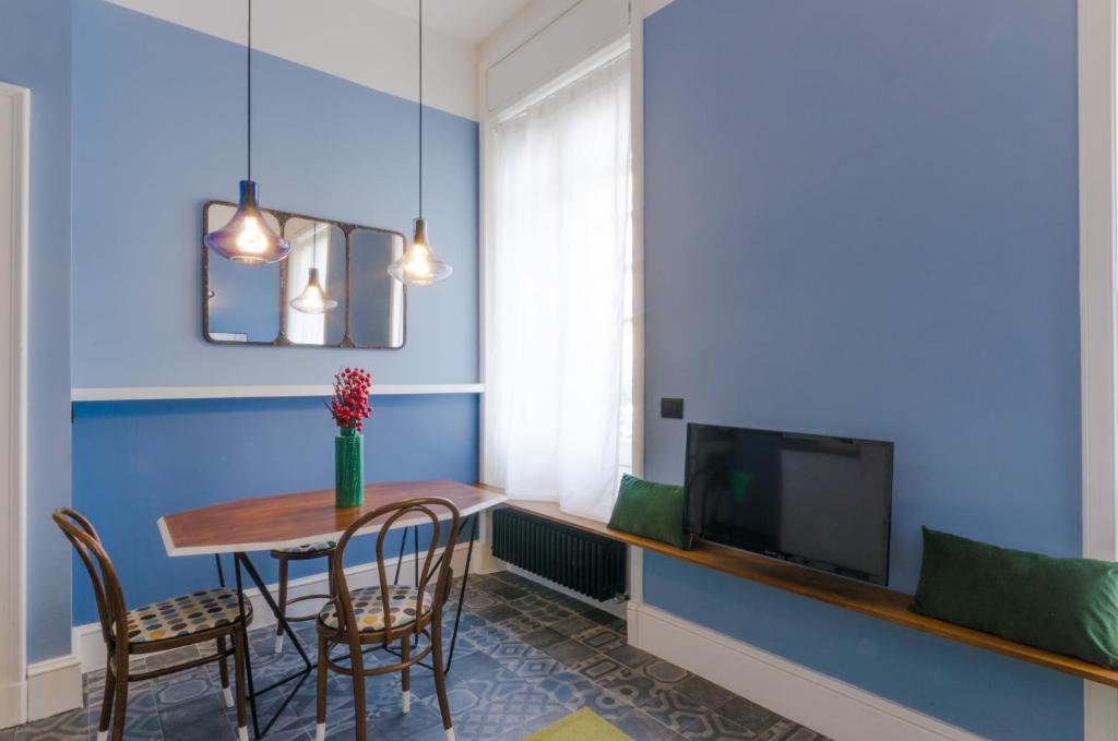 una sala da pranzo con tavolo e TV di Suite 269 a Pescara