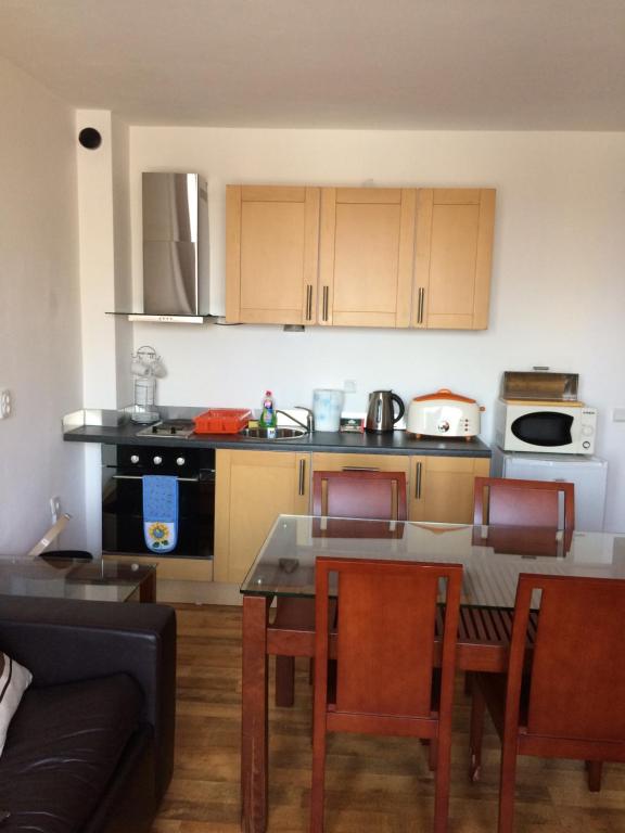 een keuken met een tafel en stoelen en een bank bij Mountain View Apartment B23 in Bansko