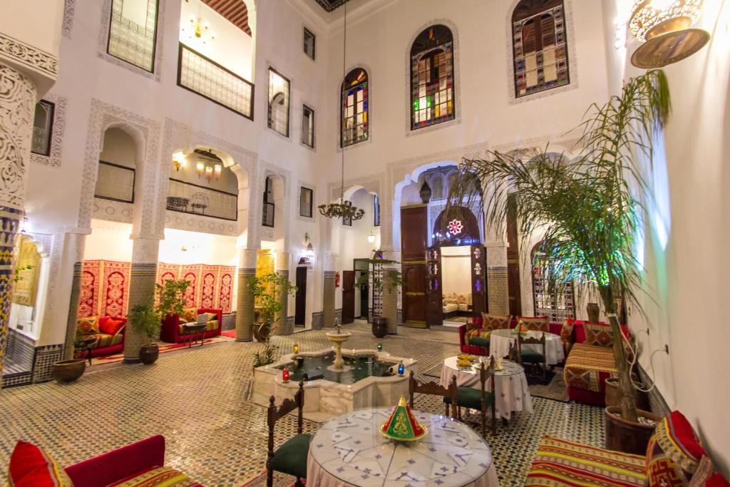 a restaurant with tables and chairs in a building at Riad Lalla Zoubida in Fès