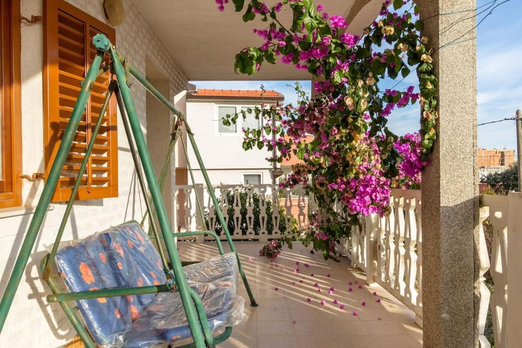 a balcony with purple flowers hanging from a fence at Apartment Zdenka 1 in Trogir