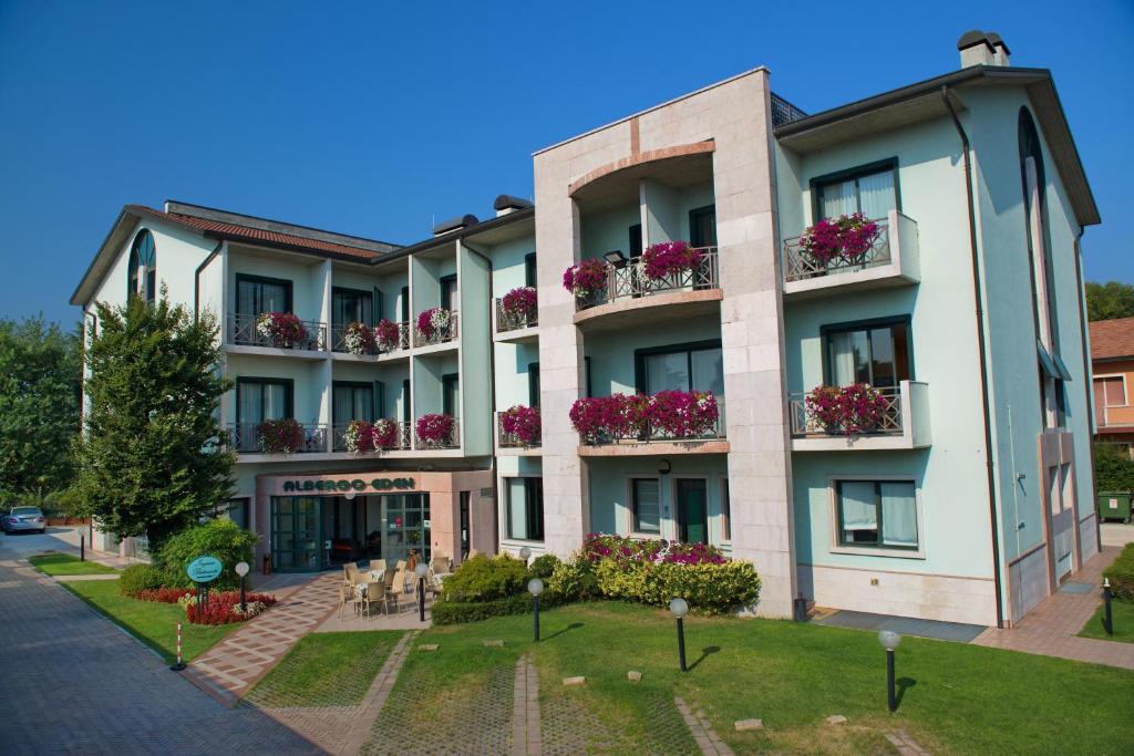 un edificio de apartamentos con flores en los balcones en Hotel Eden, en Valeggio sul Mincio