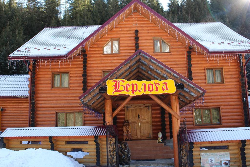 a log cabin with a sign on the front of it at Hotel Berloga-Sinevir in Synevyrsʼka Polyana