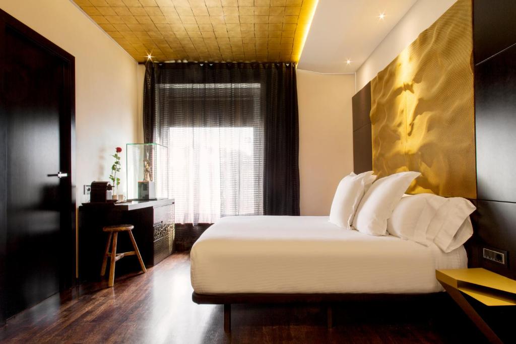 a bedroom with a bed with white pillows and a window at Claris Hotel & Spa GL, a Small Luxury Hotel of the World in Barcelona