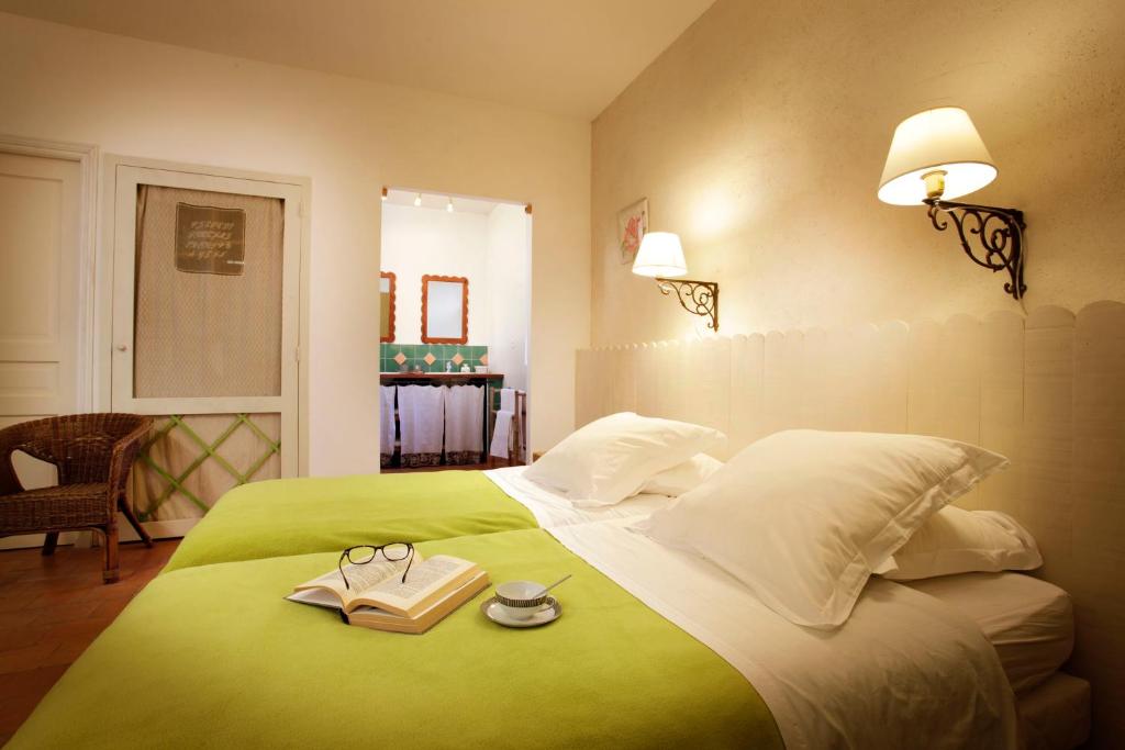 Un dormitorio con una cama verde con dos libros. en Chambres d'Hôtes Logis de l'Astrée en Saint-Bris-des-Bois