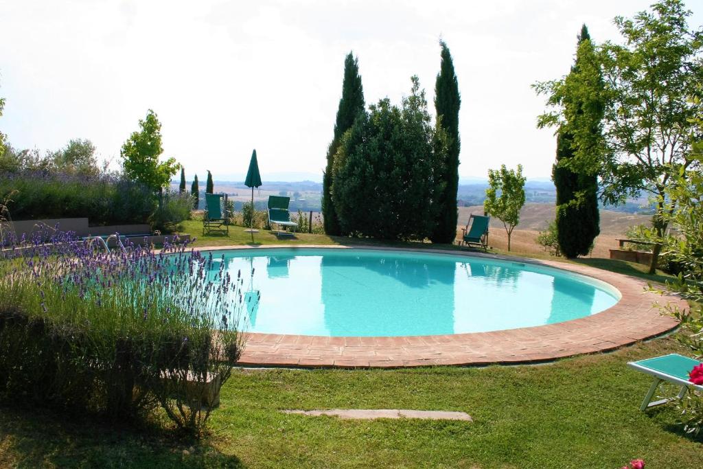 a swimming pool in a yard with trees and grass at Casa vacanze Aurora in Isola d'Arbia
