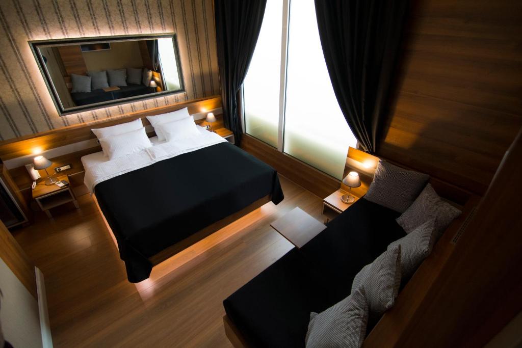 una camera con letto, specchio e divano di B&B Wimbledon Garni Concept a Belgrado