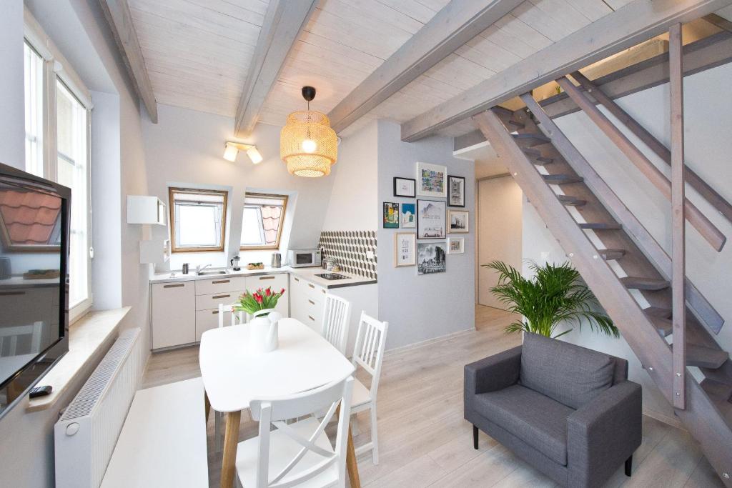 a kitchen and dining room with a staircase in a loft at Old Town Panorama Apartments in Gdańsk