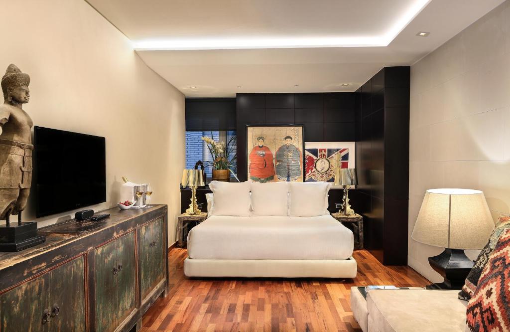 a living room with a white couch and a television at Claris Hotel & Spa GL, a Small Luxury Hotel of the World in Barcelona