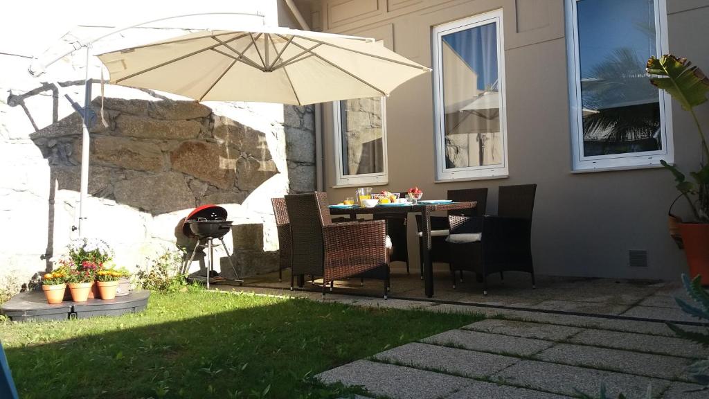 una mesa y sillas con una sombrilla en un patio en Blue Garden - oporto charming townhouse, en Oporto