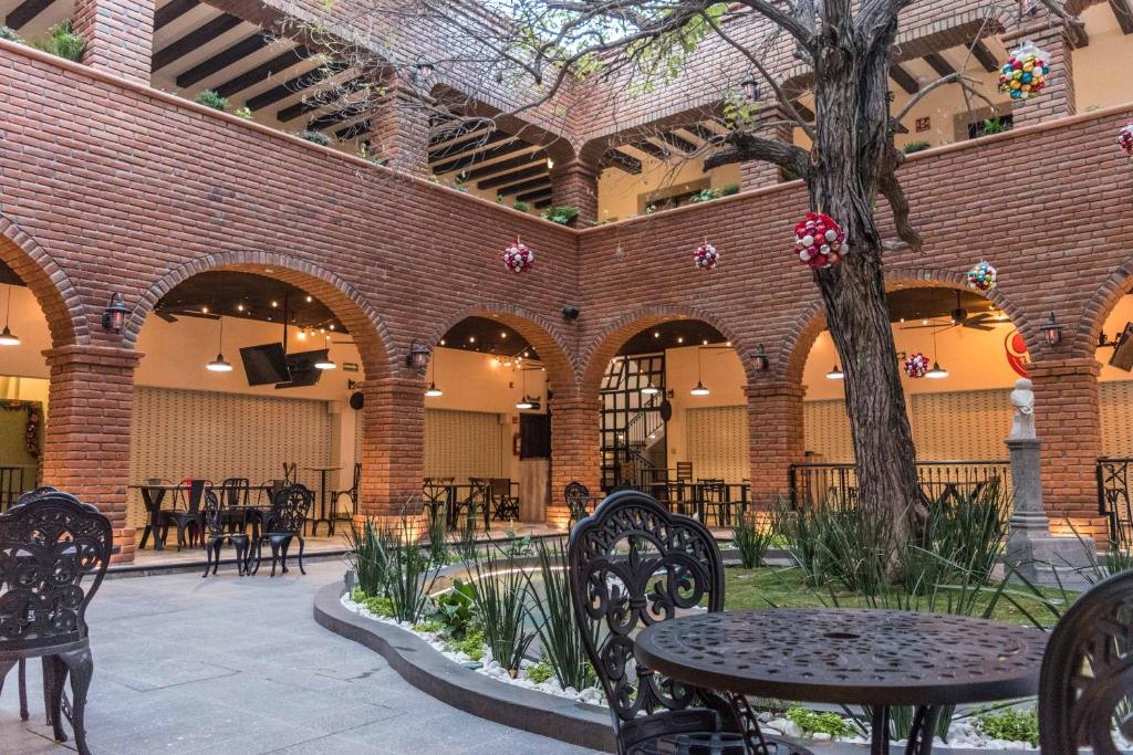 a patio with tables and chairs in a building at Punto Madero Hotel & Plaza in Mocorito