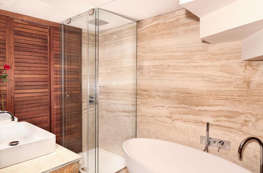 a bathroom with a shower and a tub and a sink at Claris Hotel & Spa GL, a Small Luxury Hotel of the World in Barcelona