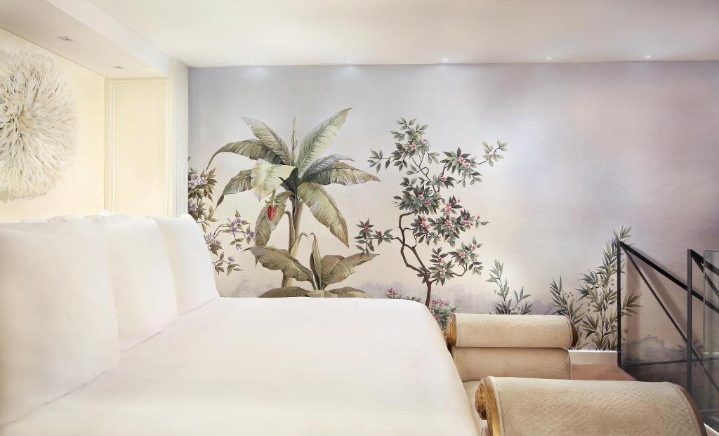 a bedroom with a white bed and a mural of plants at Claris Hotel & Spa GL, a Small Luxury Hotel of the World in Barcelona