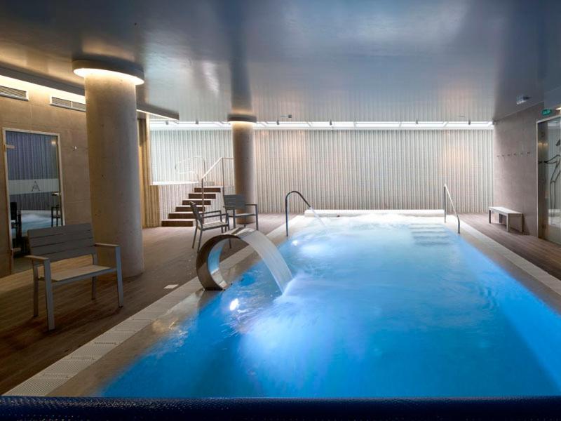 una gran piscina de agua azul en un edificio en Hotel Spa Ciudad de Astorga By PortBlue Boutique, en Astorga