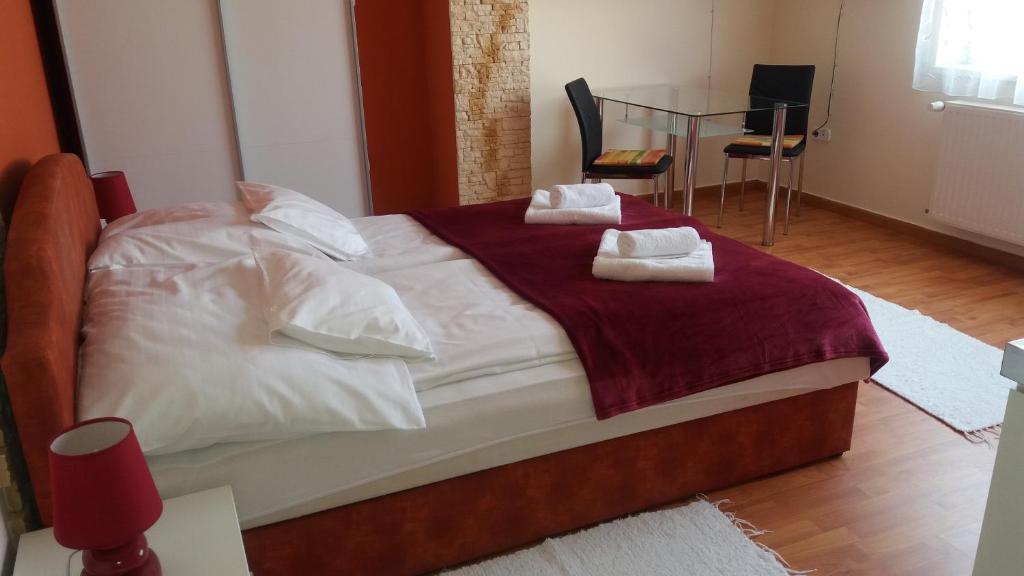 a bedroom with a large bed with towels on it at Nádor Apartmanok in Kaposvár