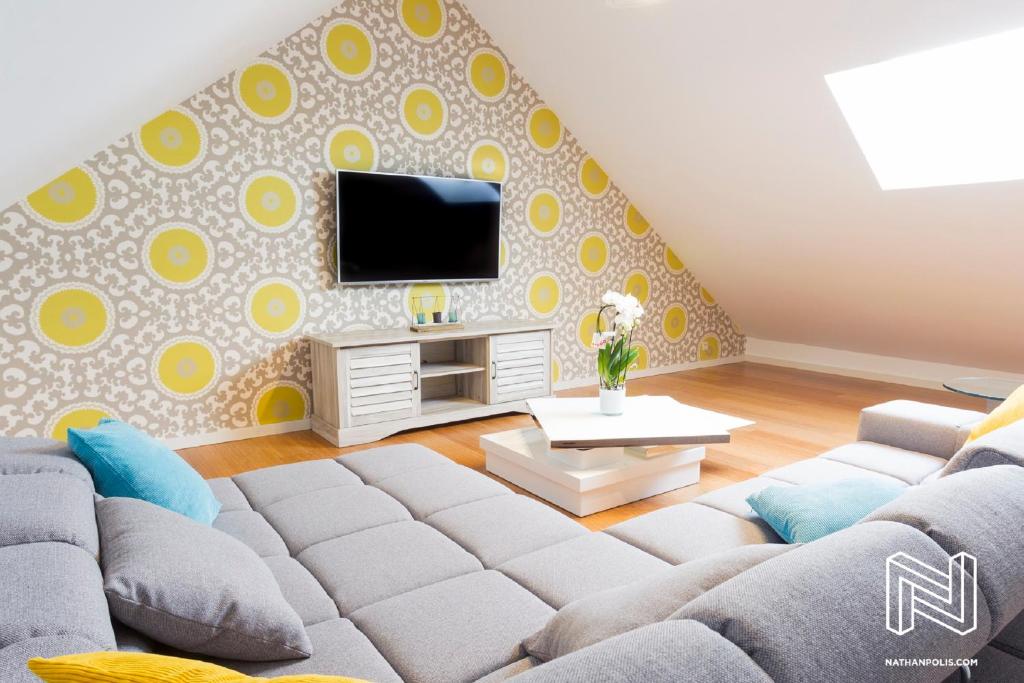 ein Wohnzimmer mit einem Sofa und einem TV in der Unterkunft Iddup Atrium in Oreye