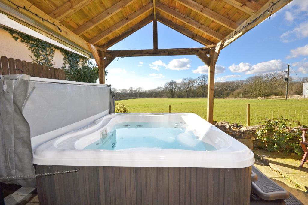 a hot tub in a gazebo in a yard at Rocklands Lodges in Pickering