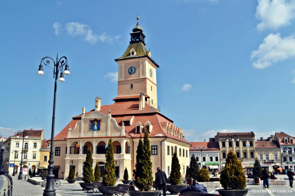 a building with a clock tower on top of it at Apartament Simon Brasov in Braşov