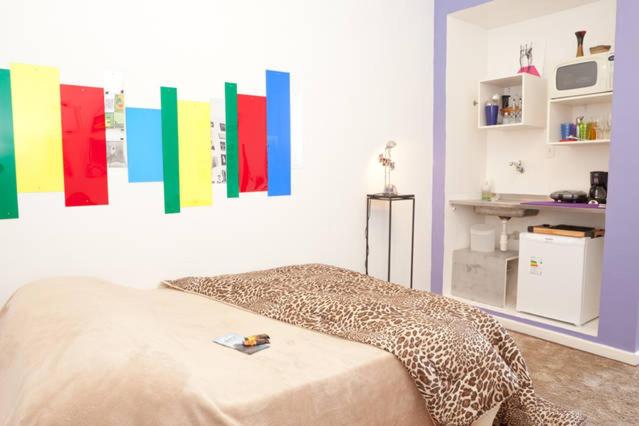 Habitación con cama con pinturas coloridas en la pared. en Lapa I Cultura Museus e Praias no Centro GR, en Río de Janeiro