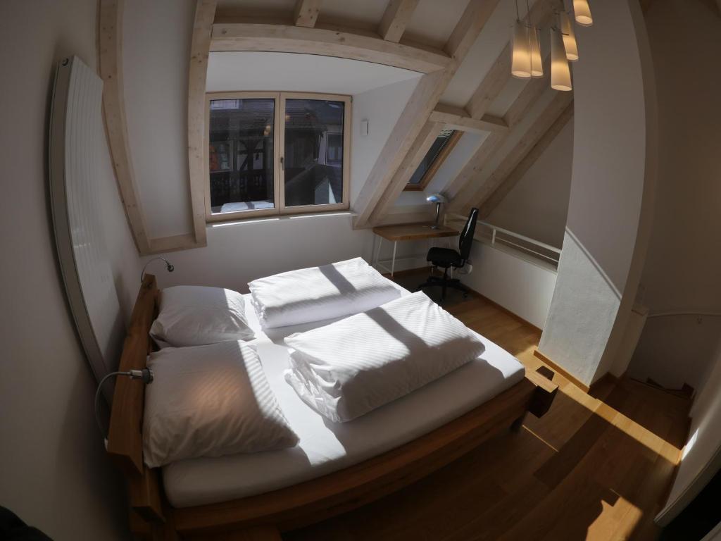 a bedroom with a bed with white sheets and a window at Haus "Zum Schwarzen Stiefel" in Bamberg
