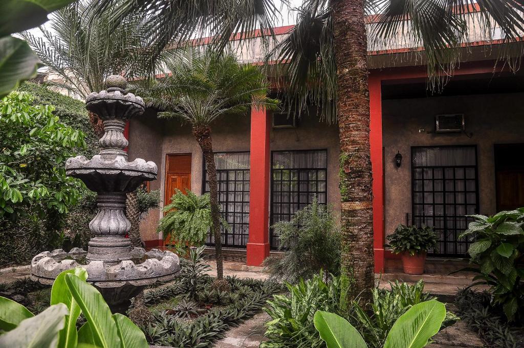 a house with a fountain in front of a building at Hotel Fenix in Tapachula