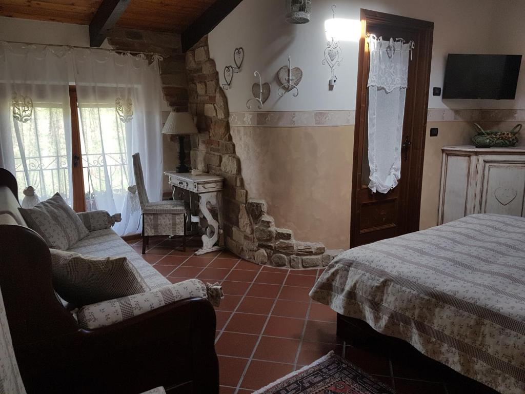 sypialnia z łóżkiem, kanapą i kominkiem w obiekcie Bed And Breakfast Olimpia w mieście San Salvatore Monferrato