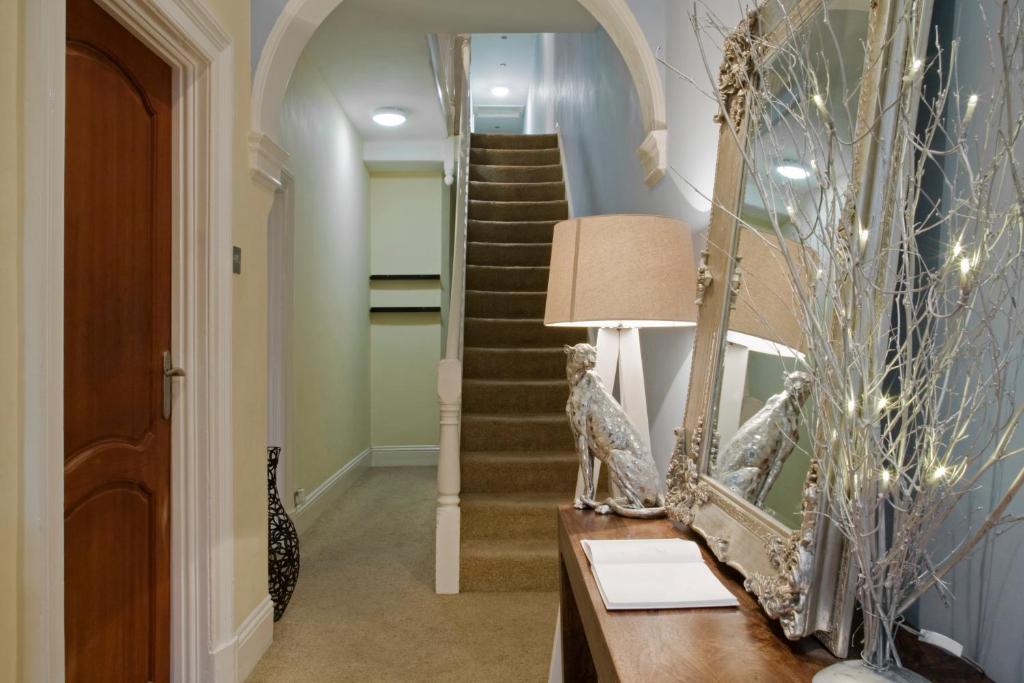 a hallway with a mirror and a stairway at Oaklands (Self Check-in) in Wolverhampton