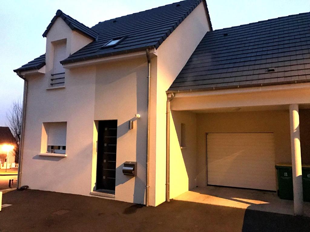 a small white house with a garage at Maison récente calme 24 heures du Mans 9 couchages in Le Mans