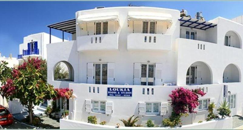un edificio bianco con un cartello davanti di Loukia Apartments & Studios a Naoussa
