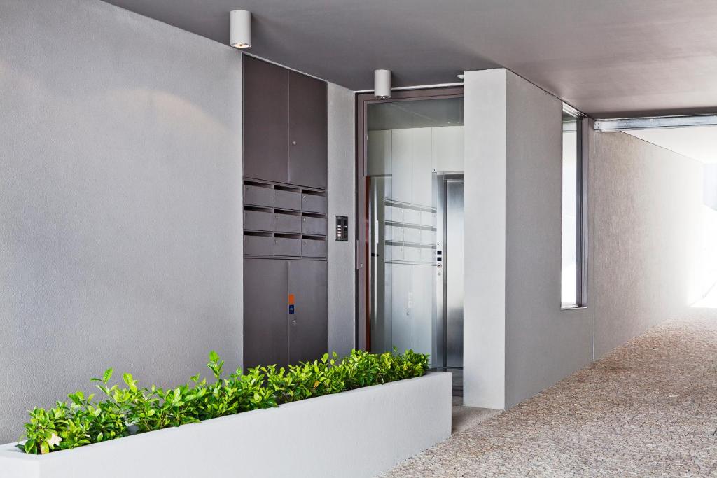 a corridor of a building with plants at bnapartments Palacio in Porto