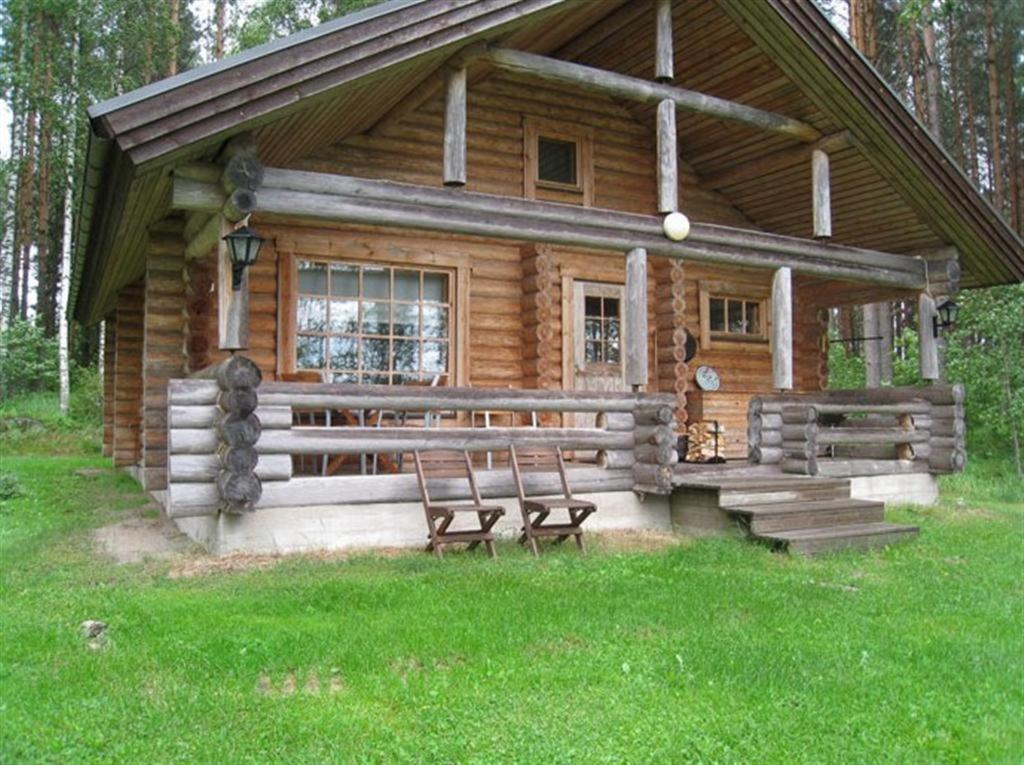 a log cabin with two chairs in front of it at Matila's Cottages in Sumiainen