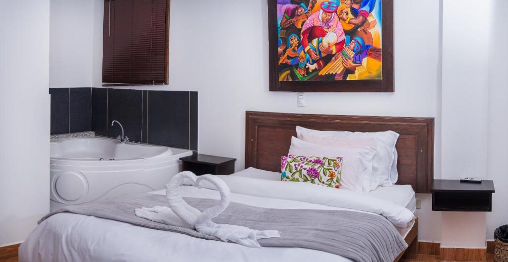 The Tayta Hostal في ماتشو بيتشو: غرفة نوم بسرير وحوض استحمام ومغسلة