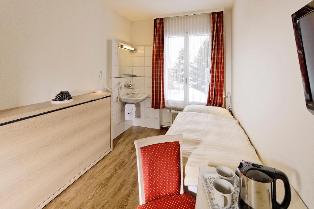 Habitación pequeña con cama y lavamanos en Hotel Beausite Budget en Interlaken
