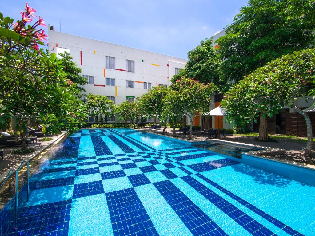 a swimming pool in front of a building at The Victoria Hotel Yogyakarta in Yogyakarta