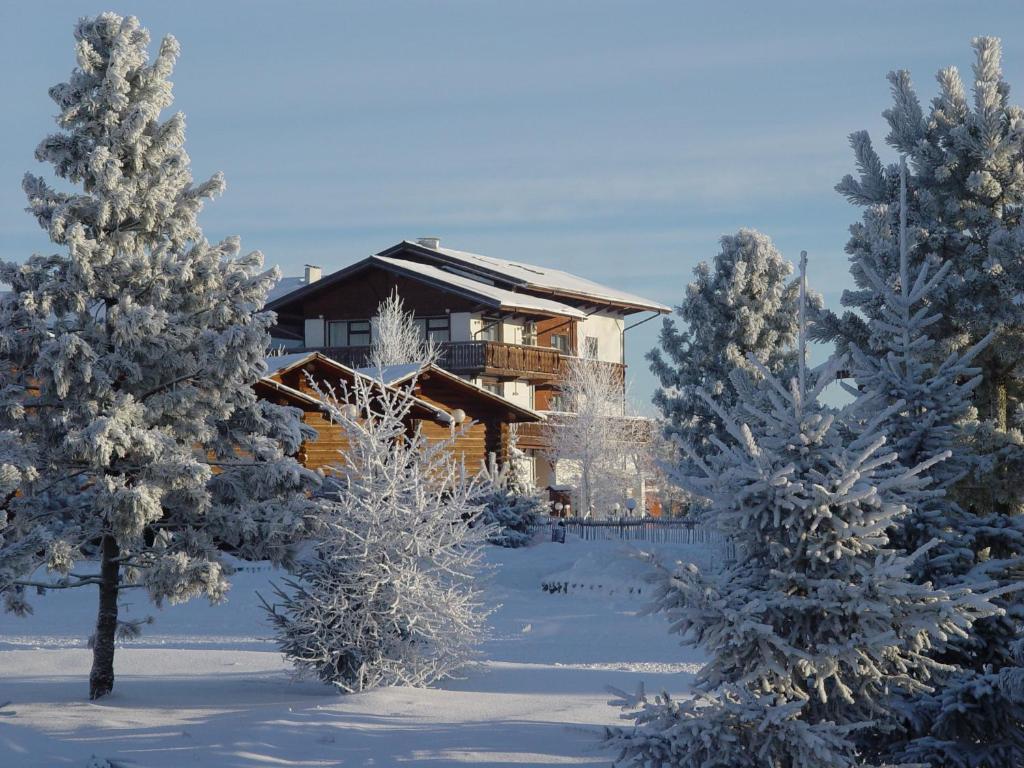 a log cabin in the snow with snow covered trees at Sport Park Volen in Yakhroma