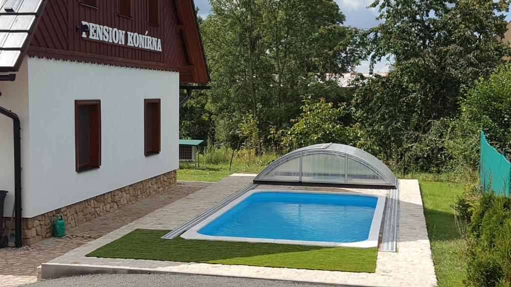 einem Pool vor einem Gebäude in der Unterkunft Pension Konírna in Huntířov