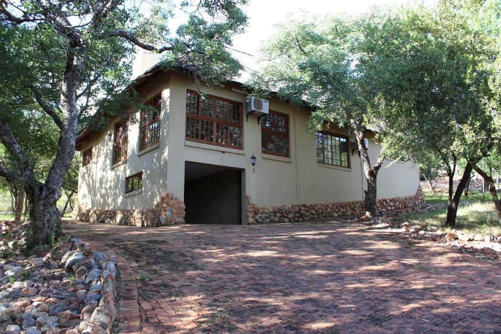a house with a driveway in front of it at Thabaledi Game Lodge in Brits