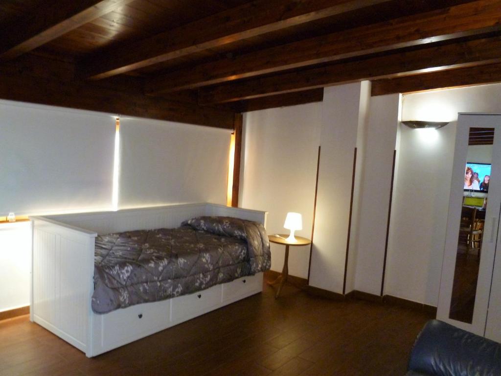 フランカヴィッラ・フォンターナにあるLa Mansarda di Pupilloのベッドルーム1室(ベッド1台、ランプ付きテーブル付)