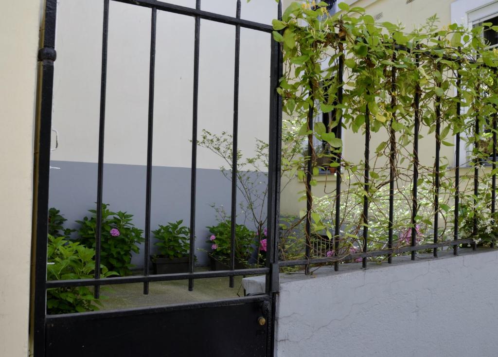 une porte noire avec des fleurs sur un balcon dans l'établissement La Cour du 5ème - Chambre d'hôtes, à Paris
