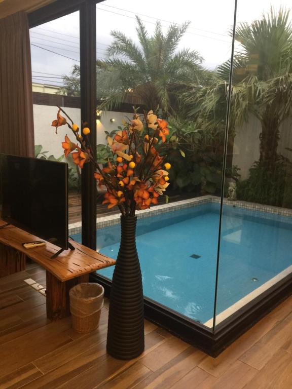 un vaso con fiori di fronte alla piscina di Mou Xia Villa a Wujie